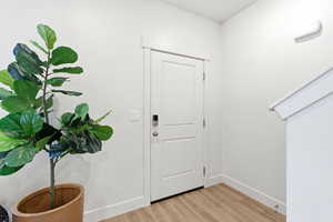 Entryway with baseboards and light wood finished floors