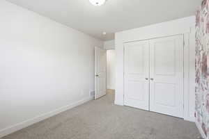 Unfurnished bedroom featuring carpet and a closet