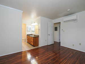 Unfurnished bedroom featuring light wood-type flooring, ornamental molding, electric panel, and ensuite bathroom