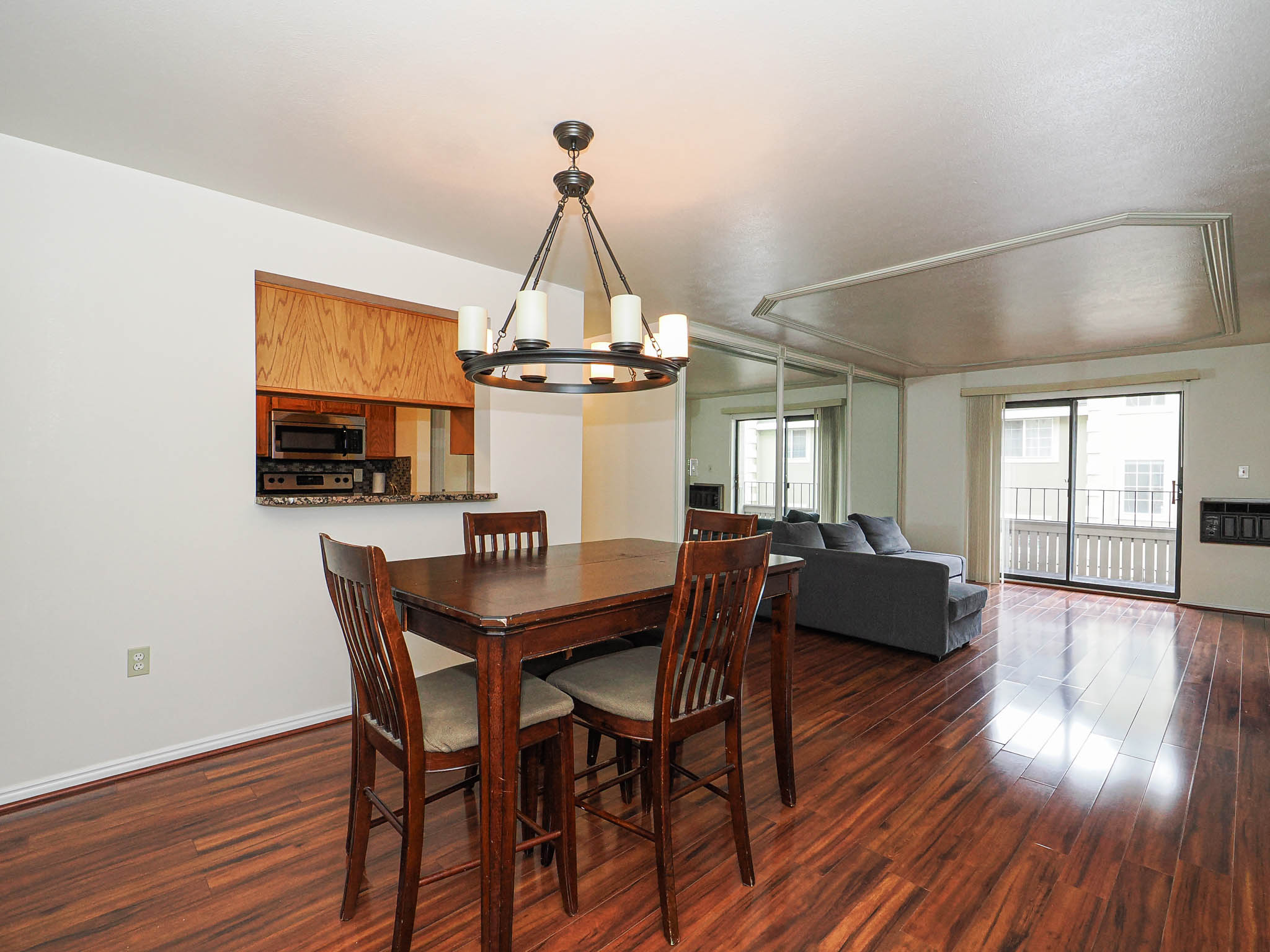 Dining area featuring dark wood-style flooring, suspended lighting, and heating unit