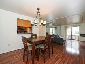 Dining area featuring dark wood-style flooring, suspended lighting, and heating unit