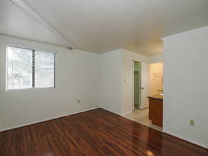 Unfurnished room featuring light wood-type flooring and ornamental molding