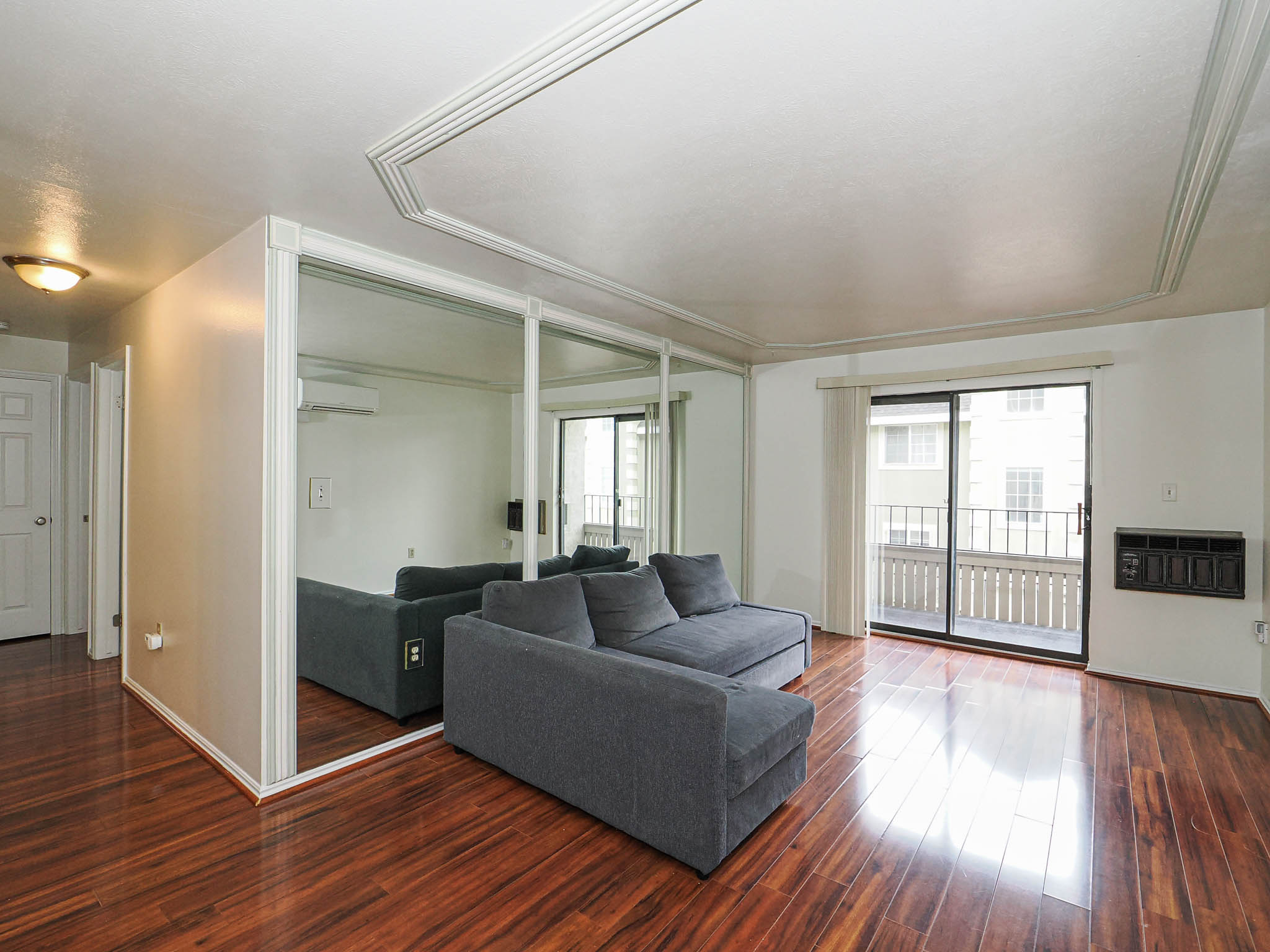 Living area with wood finished floors and heating unit