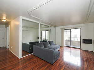 Living area with wood finished floors and heating unit