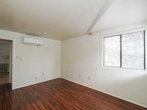 Spare room with dark wood-style floors and ornamental molding