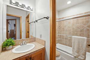Bathroom featuring bath / shower combo with glass door and vanity