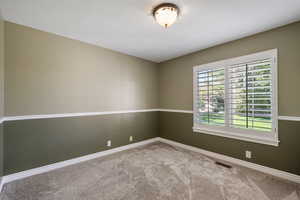Spare room with light carpet and baseboards