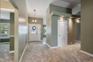 Foyer featuring light carpet and suspended lighting