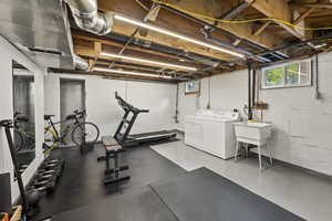 Exercise area with concrete floors, healthy amount of natural light, and washing machine and dryer