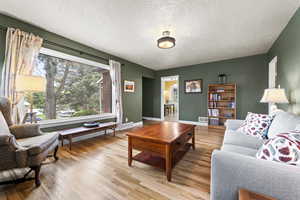Living room featuring light wood-style flooring and a textured ceiling