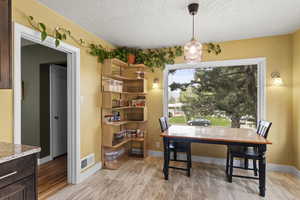 Dining area featuring a textured ceiling and a desk