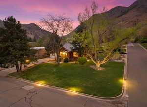 View of front facade with a mountain view and a yard