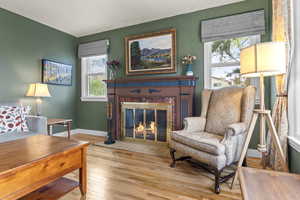Living area featuring hardwood / wood-style flooring, a brick fireplace, and a textured ceiling