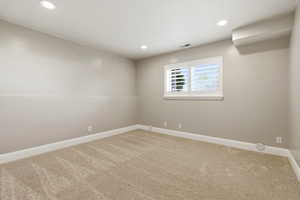 Empty room featuring light carpet and recessed lighting