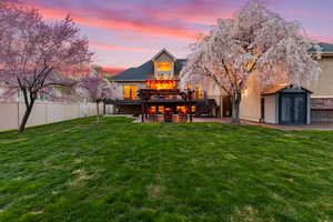 Rear view of house with a patio area, a deck, a shed, and stucco siding