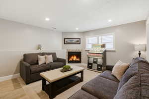 Living area with a lit fireplace and recessed lighting