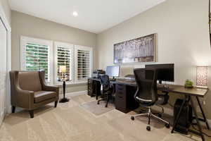Home office with light carpet and recessed lighting
