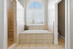 Bathroom with a bath, light tile patterned floors, and a walk in shower