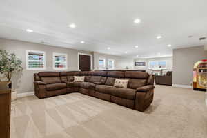 Living area featuring light colored carpet and recessed lighting