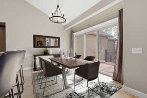 Dining area featuring lofted ceiling, suspended lighting, and light tile patterned floors