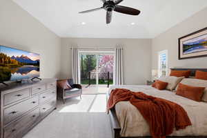 Bedroom with access to outside, light carpet, ceiling fan, and multiple windows