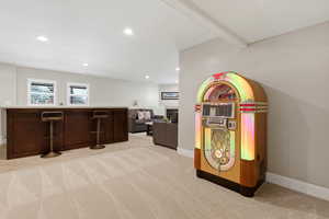 Game room with light carpet, a fireplace, recessed lighting, and a bar