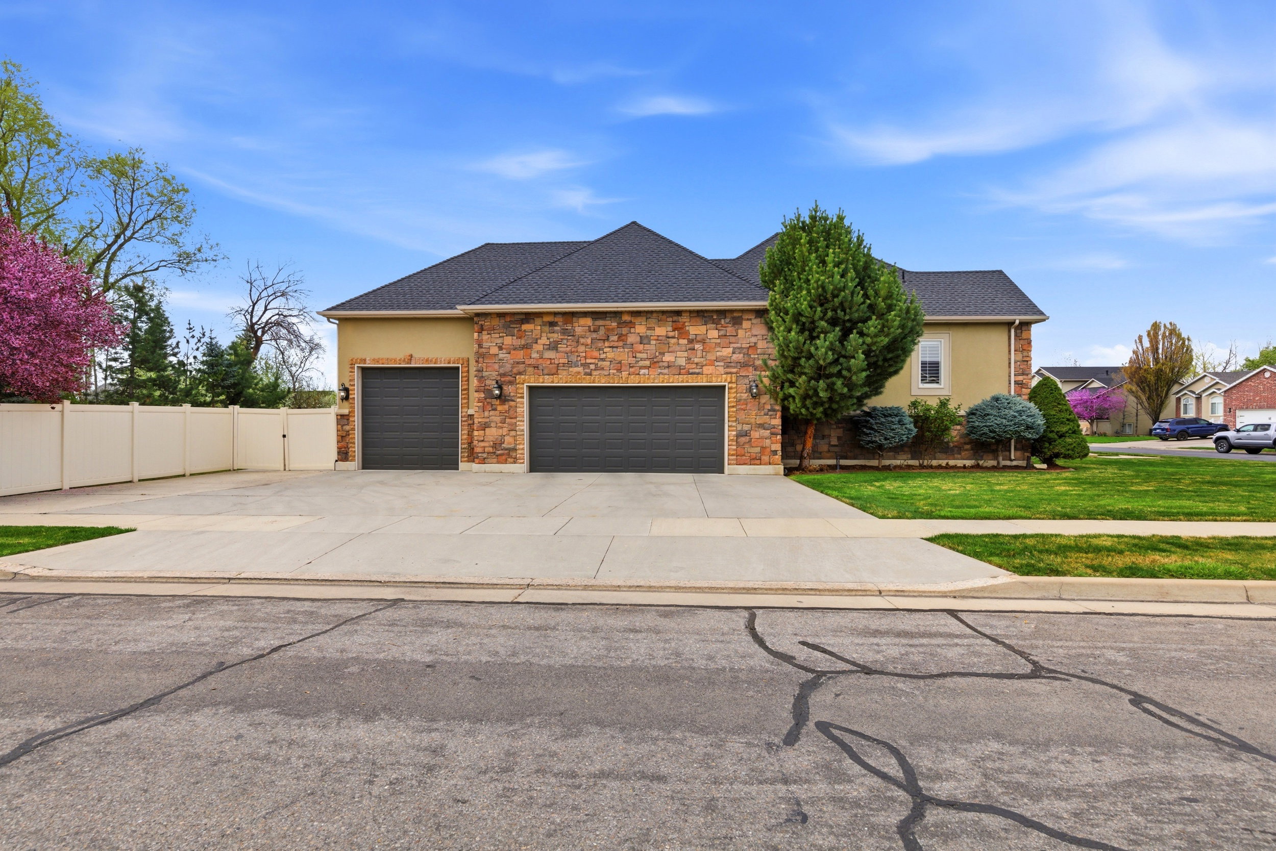 View of front of property featuring stucco siding, an attached garage, concrete driveway, roof with shingles, and stone siding