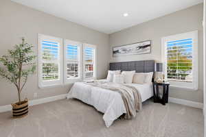 Bedroom featuring baseboards and light colored carpet