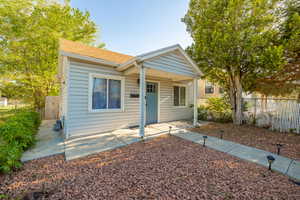 Bungalow featuring a patio and a shingled roof
