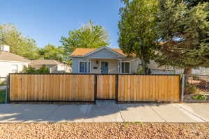 Bungalow-style home featuring a fenced front yard and a gate