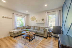 Living room featuring light wood finished floors and recessed lighting
