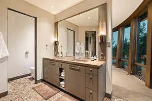 Full bathroom with double vanity and light carpet