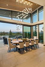 Dining area featuring a high ceiling, hanging lights, a mountain view, and plenty of natural light