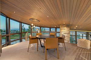 Dining area with wooden ceiling, expansive windows, carpet floors, recessed lighting, and a mountain view