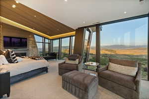 Bedroom with a mountain view, floor to ceiling windows, carpet floors, recessed lighting, and a vaulted wood ceiling