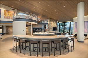 Kitchen with a high wooden ceiling, recessed lighting, a fireplace, floor to ceiling windows, and a breakfast bar area