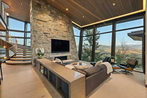 Living area with expansive windows, a fireplace, a vaulted wood ceiling, and recessed lighting