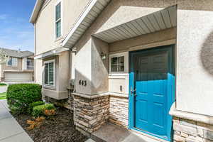 View of exterior entry featuring stone siding and stucco siding