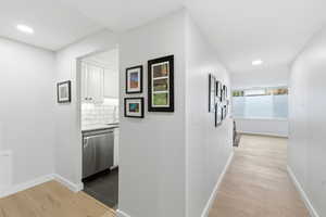 Corridor with light wood-style floors and recessed lighting