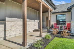 Covered front porch featuring wood-finish columns and a wood-finish ceiling