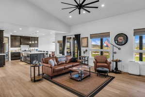 Open-concept living space featuring wood-finish flooring, vaulted ceilings, and recessed lighting