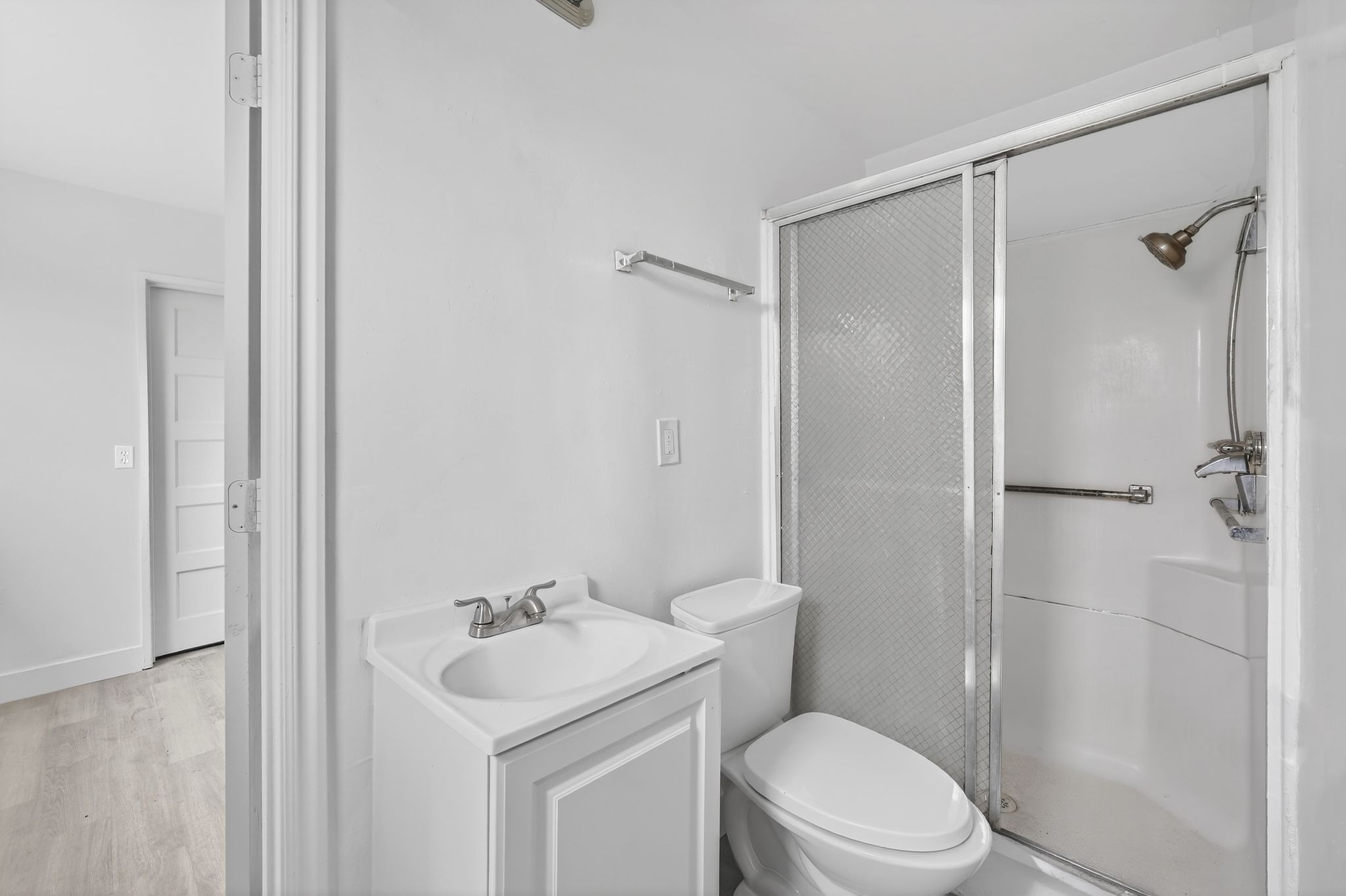 Bathroom with vanity, a stall shower, and light wood-style floors