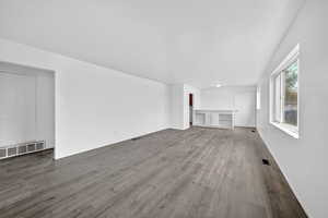 Unfurnished living room with dark wood-type flooring