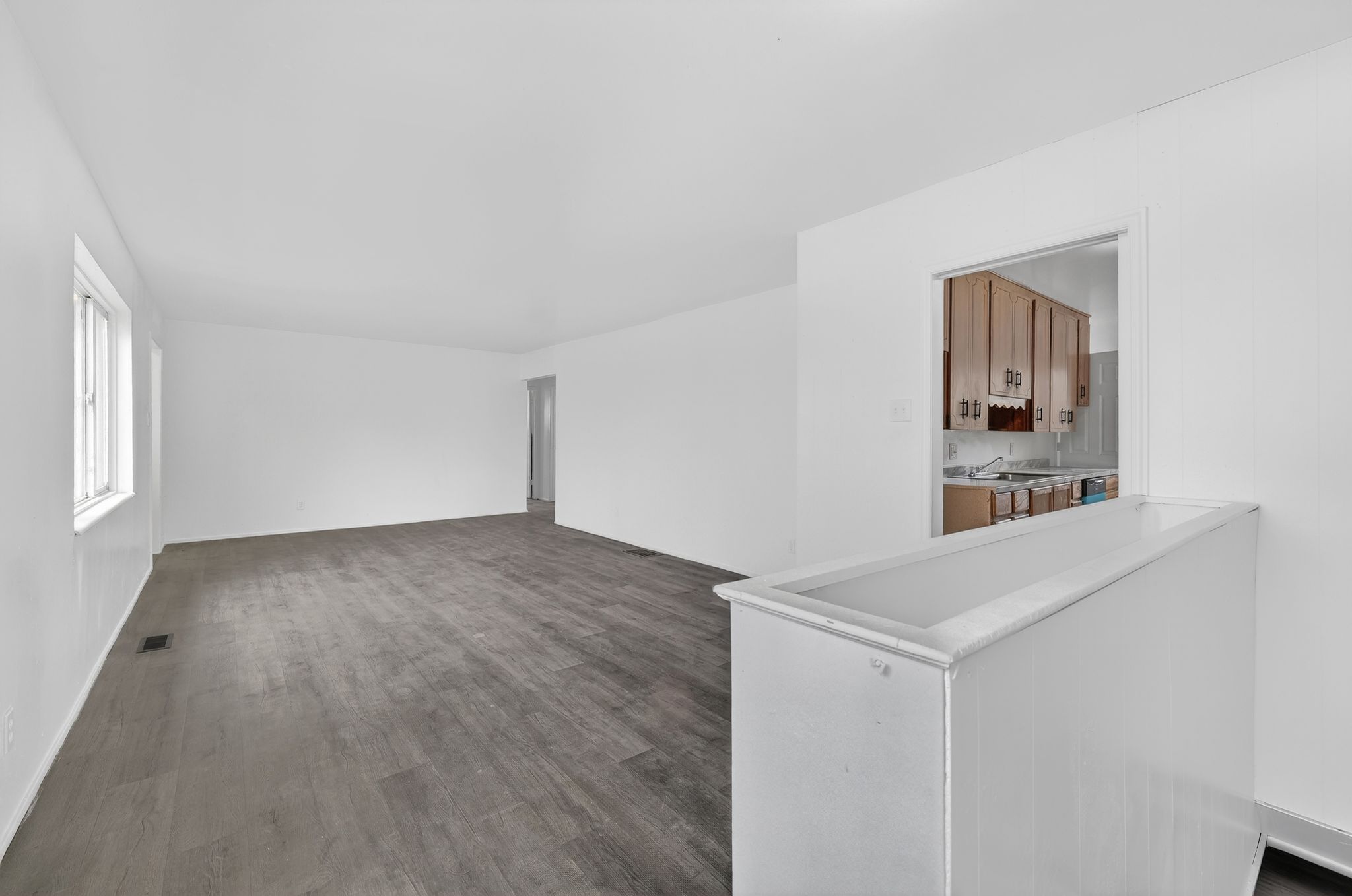 Empty room featuring dark wood-style flooring and a sink