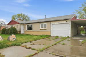 Single story home with brick siding, driveway, a garage, and an attached carport