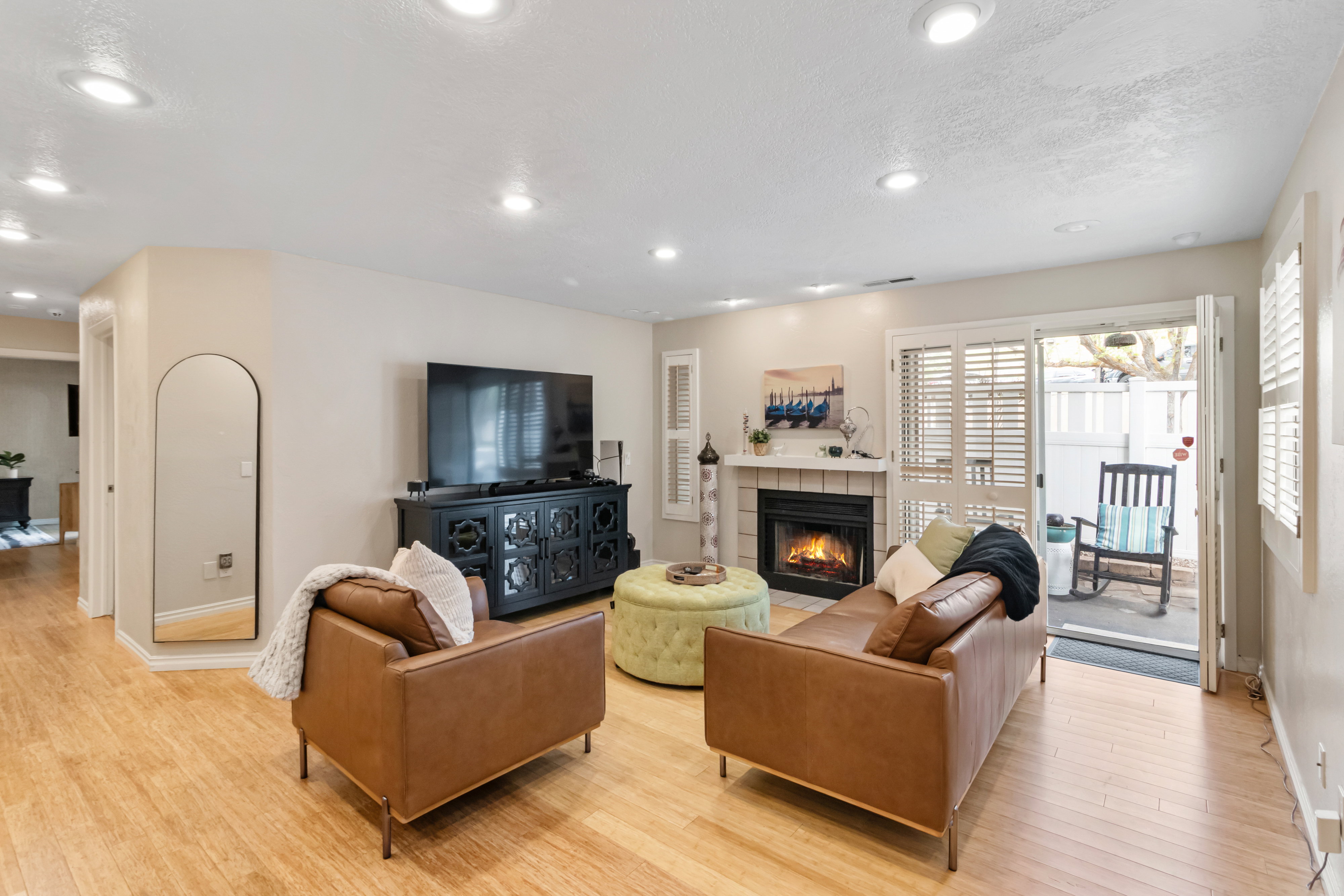 Living room with a tile fireplace, light wood finished floors, recessed lighting, and a textured ceiling