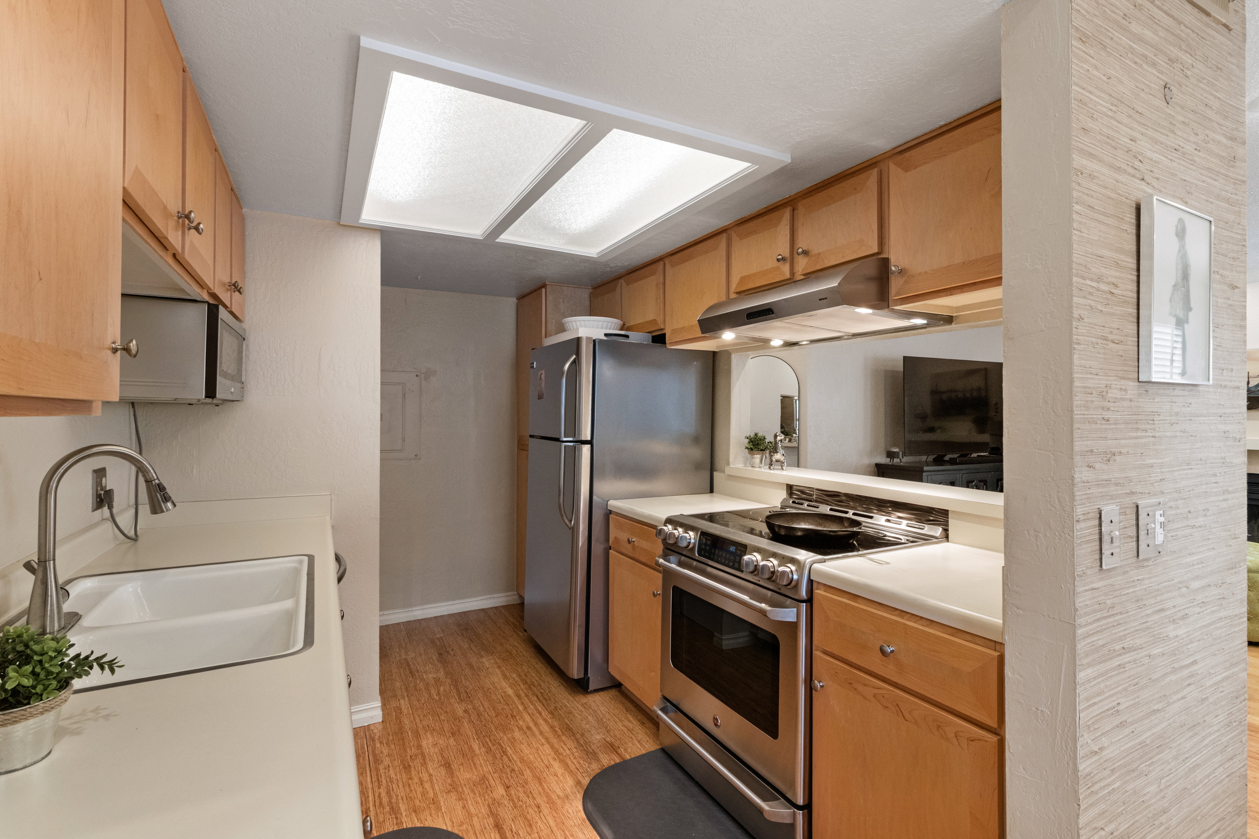 Kitchen featuring stainless steel appliances, light countertops, and light wood-style flooring