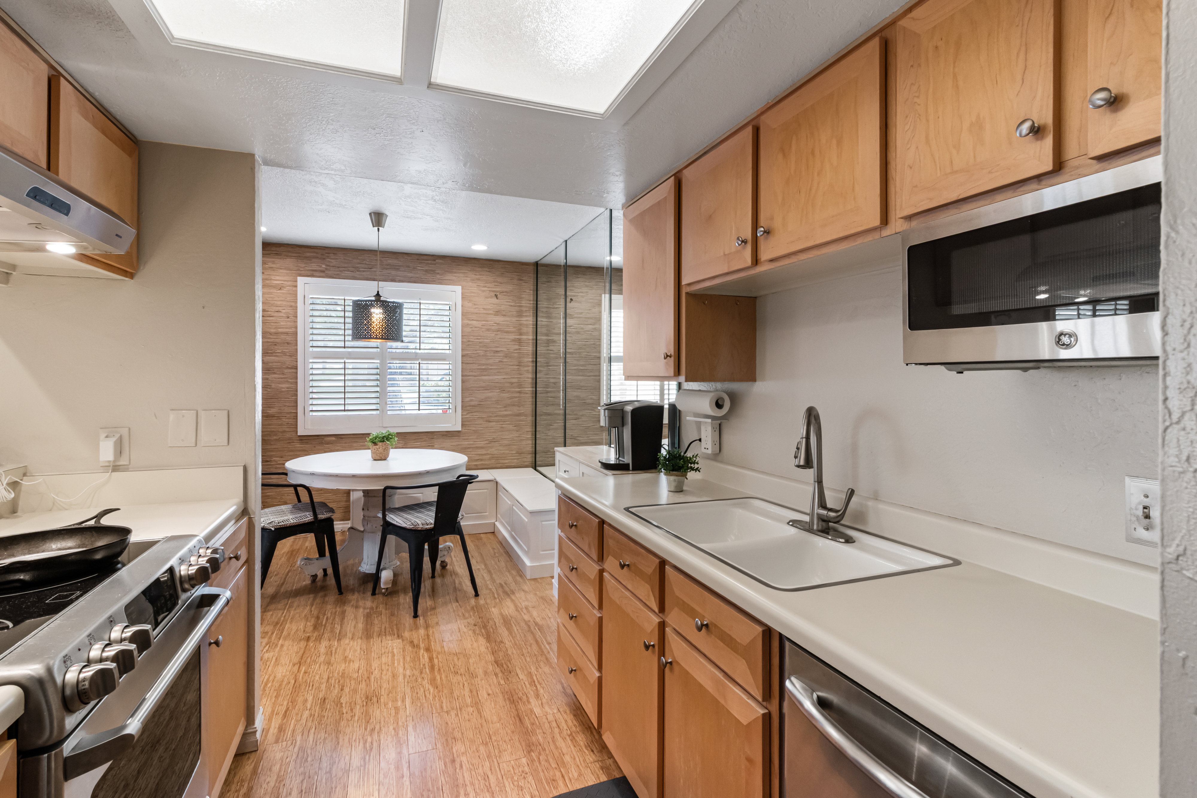Kitchen with stainless steel appliances, light countertops, light wood finished floors, and wood finish cabinets