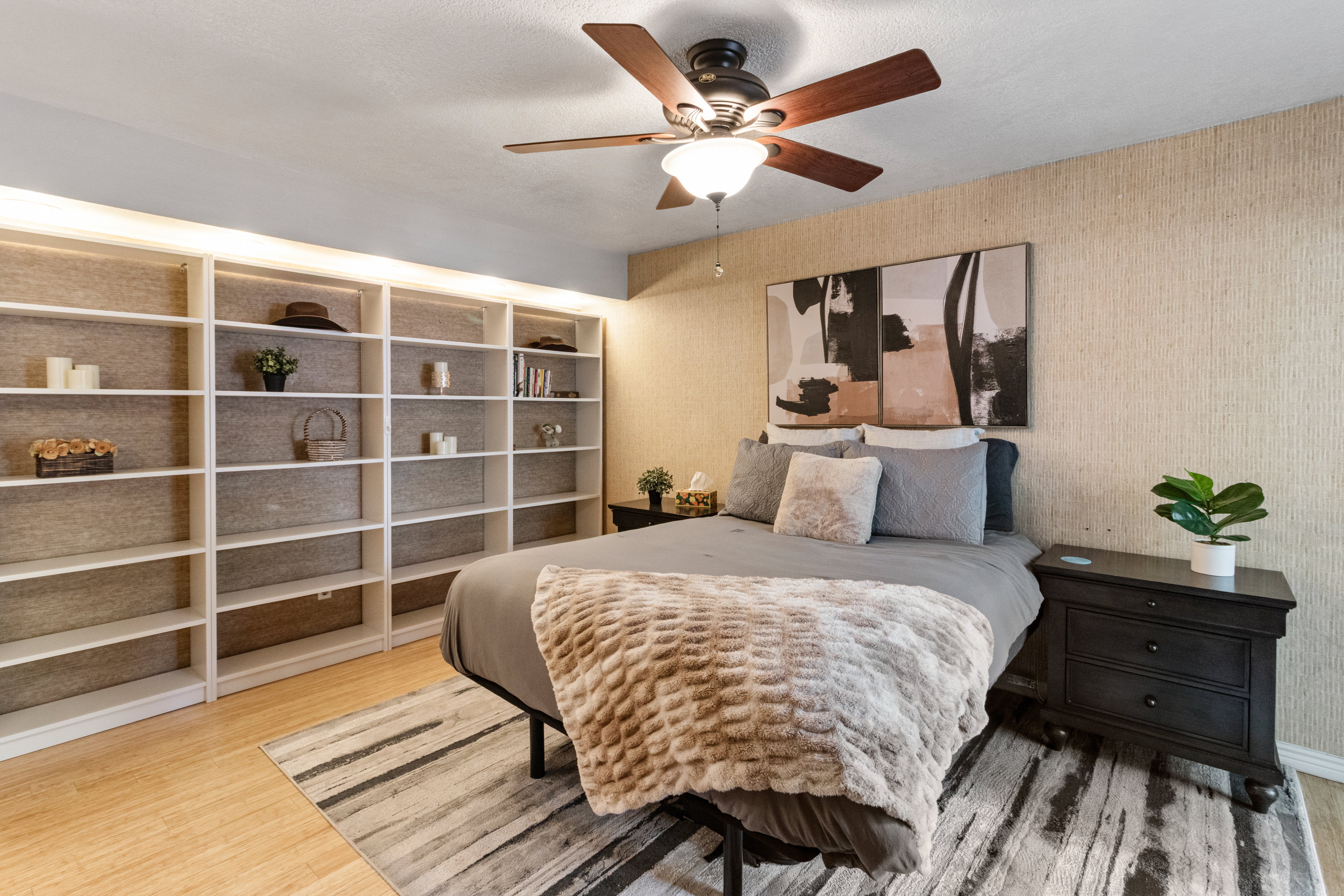 Bedroom with wallpapered walls, ceiling fan, and light wood-style flooring