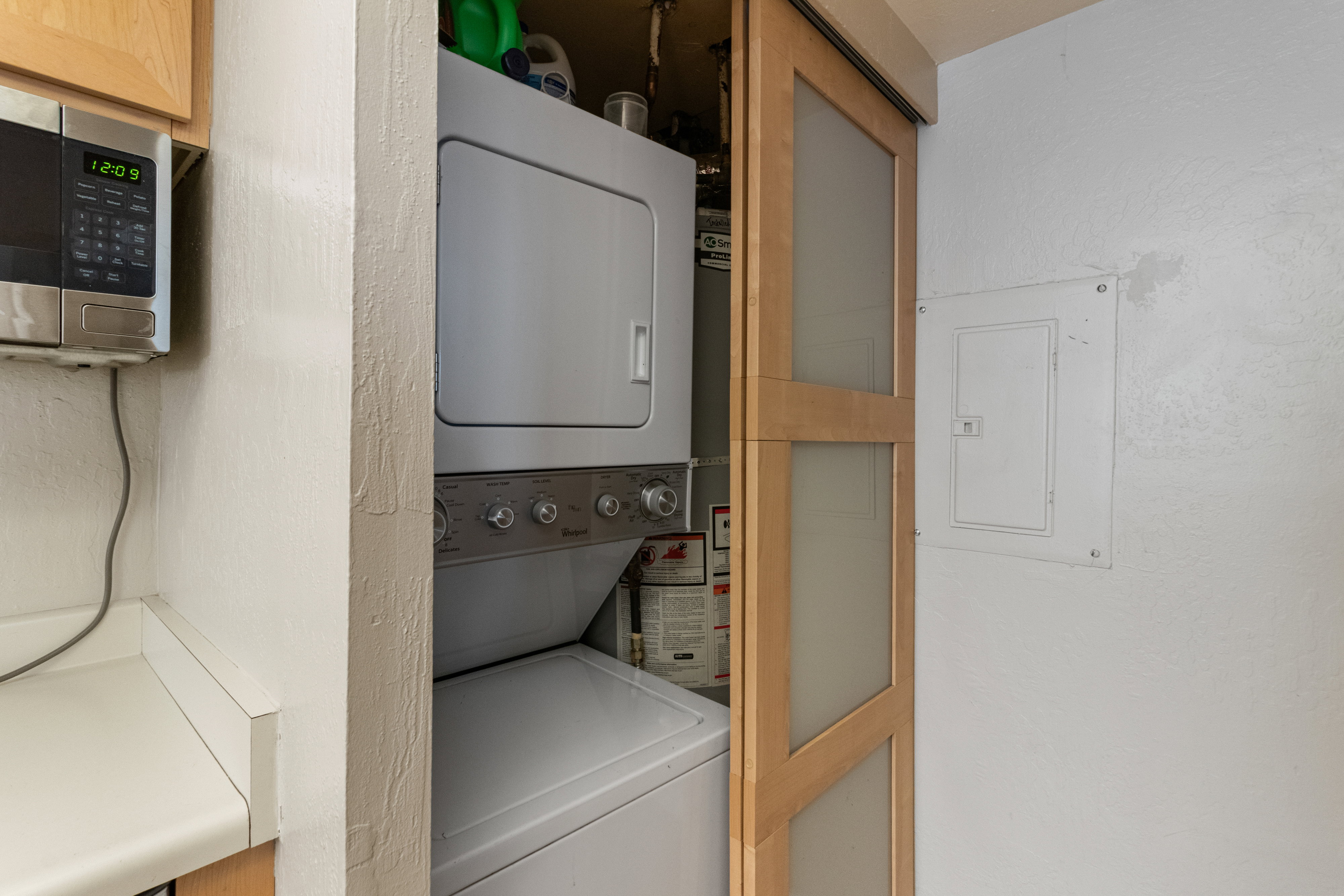 Laundry room with stacked washer / drying machine and electric panel